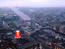 Crane & Safety staff suspended in a personnel basket inspecting the aircraft warning light on a tower 150m above the city centre in Dublin, Ireland